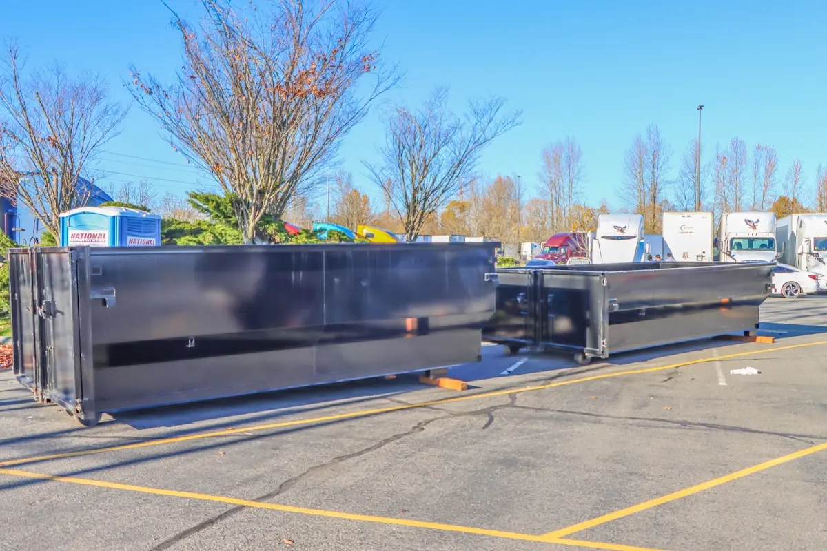 Professional dumpster rental service with roll-off container on residential driveway in Elk Plain